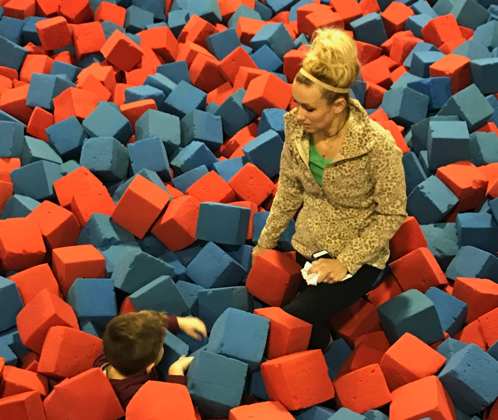 A mother and child play in the foam pit